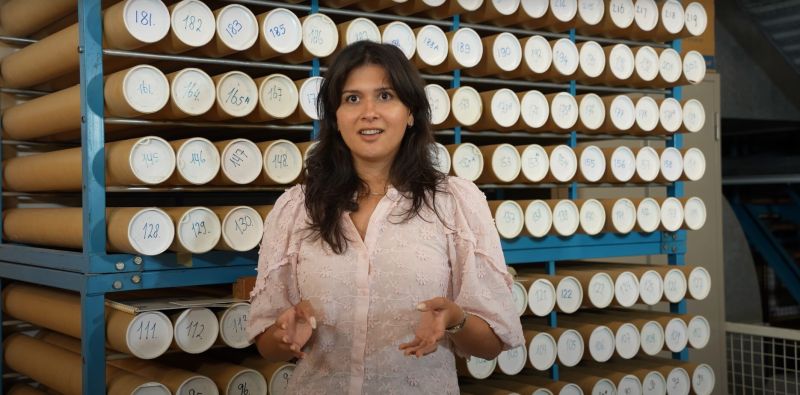 Bezoeker bekijkt een opengesteld archiefstuk in de tentoonstelling Opgedoken in het Maritiem Museum Rotterdam, vastgelegd door Gwen Lemmers.
