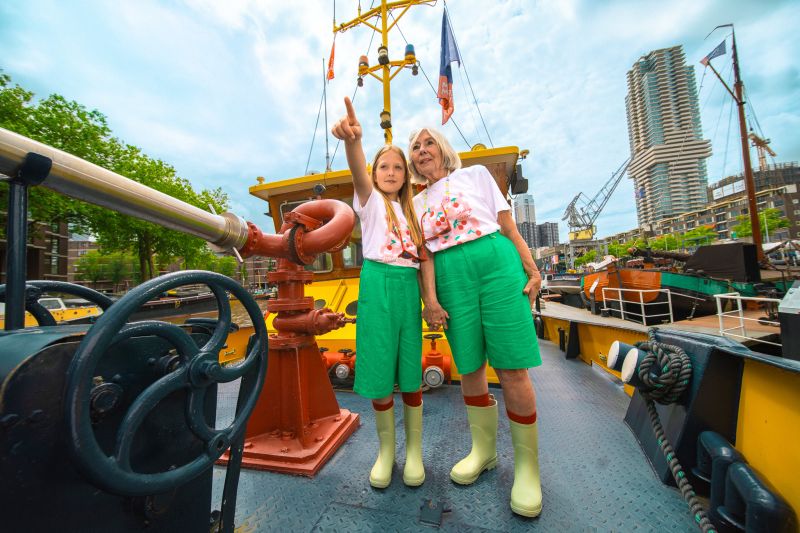 Portret van oma en kleindochter die lachend poseren in promotiefoto’s van de zomercampagne 2024 van het Maritiem Museum Rotterdam.