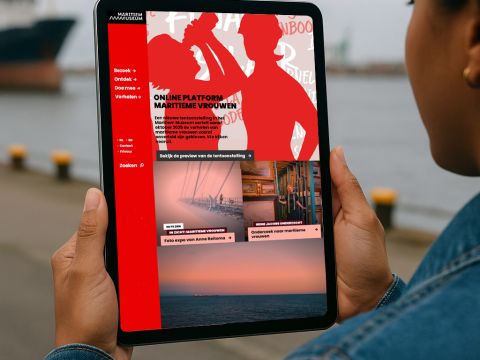 Groep vrouwen op een platformboard, samen op een houten tribune in het Maritiem Museum Rotterdam, mogelijk onderdeel van een groepsevenement of bijeenkomst.