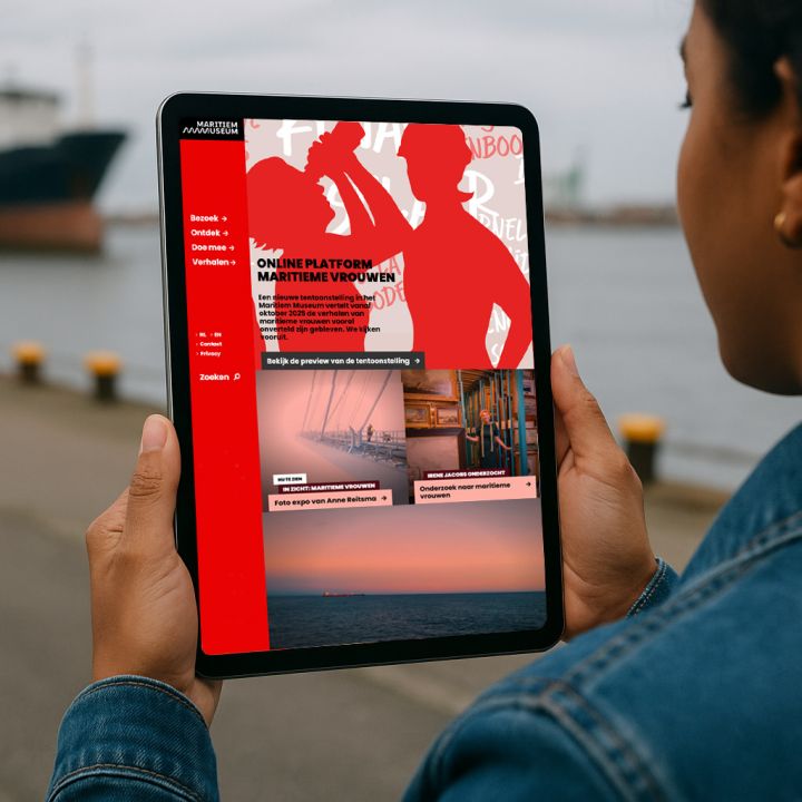 Groep vrouwen op een platformboard, samen op een houten tribune in het Maritiem Museum Rotterdam, mogelijk onderdeel van een groepsevenement of bijeenkomst.