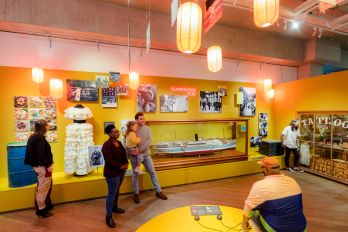 Twee jonge bezoekers staan nieuwsgierig voor een groot infopaneel over havenontwikkeling in de expositie Bestemming Havenstad in het Maritiem Museum Rotterdam.