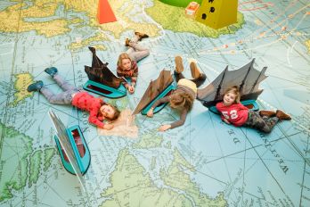 Kinderen spelen met schepen op tentoonstellingsvloer