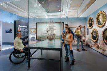 Bezoekers wandelen langs interactieve panelen en tentoonstellingsborden in de expo ‘Bestemming Havenstad’ van het Maritiem Museum Rotterdam, gefotografeerd door Marco de Swart.