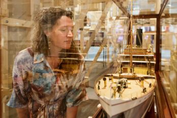 Bezoeker bewondert scheepsmodel in de tentoonstelling De Haven